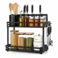 Black 2-tier kitchen organizer rack with spice jars, storage containers, utensils and kitchen accessories on a white background